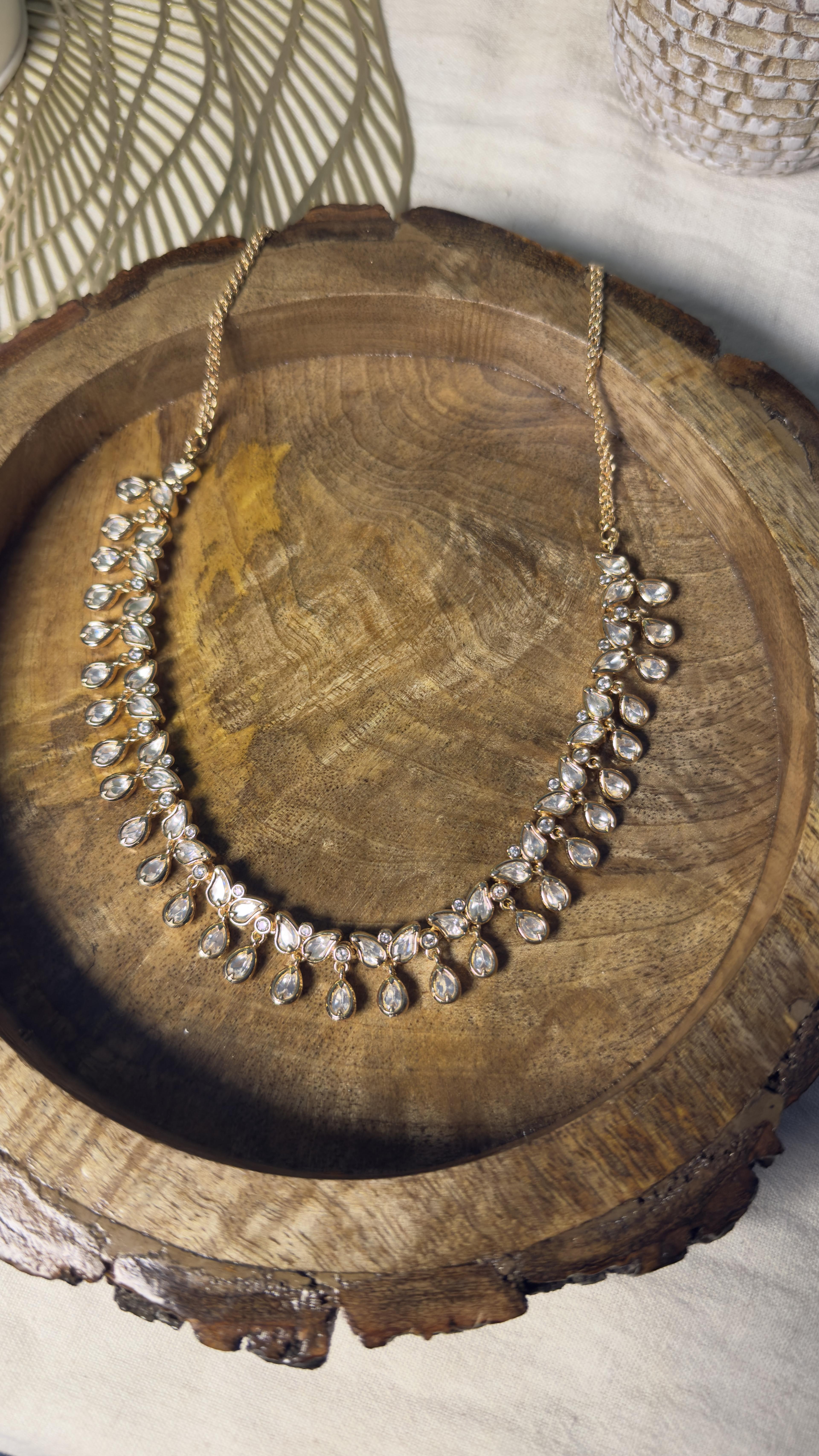 Samridhi Collection teardrop blossom minimal necklace on carved wooden platter